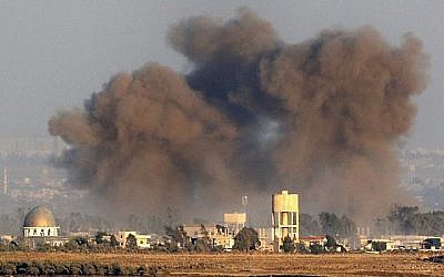 Une photo prise le 26 juillet 2018, près du kibboutz Ein Zivan sur les hauteurs du Golan israélien, montre de la fumée s'élevant au-dessus des bâtiments de l'autre côté de la frontière syrienne lors de frappes aériennes soutenant une offensive menée par le gouvernement dans la province de Quneitra, au sud du pays. (AFP Photo/Jack Guez)