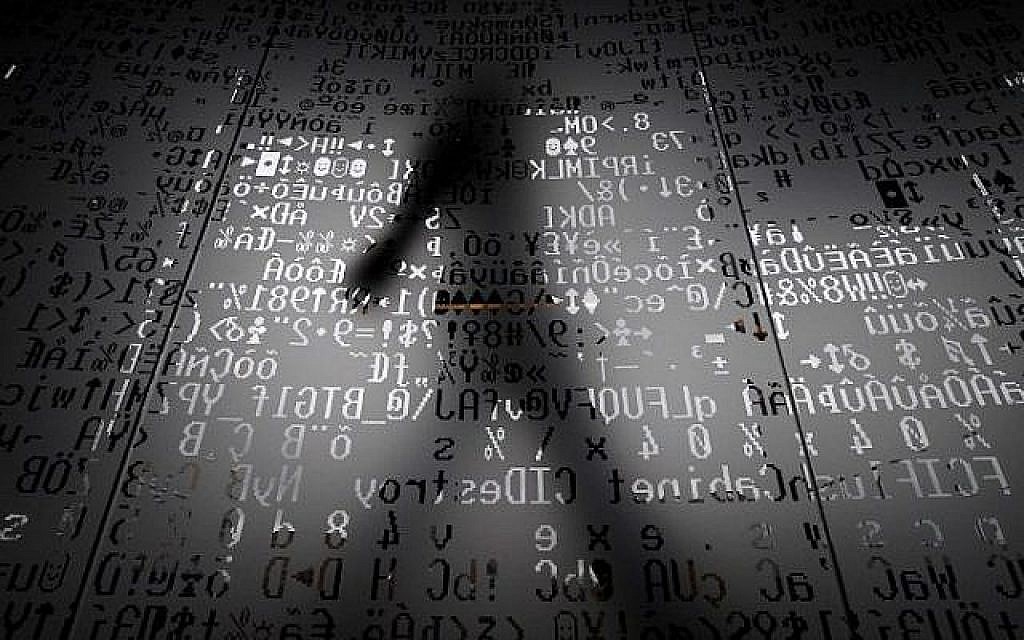 Une photo prise le 17 octobre 2016 montre un employé marchant derrière un mur de verre avec des symboles codés par machine au siège du géant de la sécurité Internet Kaspersky à Moscou. (AFP/Kirill KUDRYAVTSEV)