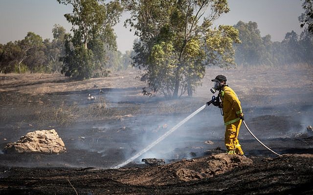 Les pompiers éteignent un incendie dans un champ allumé par des des combustibles attachés à des cerfs-volants envoyés depuis la bande de Gaza par des Palestiniens, le 27 juin 2018 (Crédit : Flash90) Les pompiers éteignent un incendie dans un champ allumé par des des combustibles attachés à des cerfs-volants envoyés depuis la bande de Gaza par des Palestiniens, le 27 juin 2018 (Crédit : Flash90)