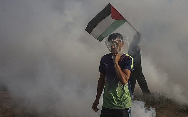 Des gaz lacrymogènes lancés par les troupes israéliennes retombent sur des Palestiniens durant une manifestation à la frontière entre Israël et Gaza, le 13 juillet 2018 (Crédit : Wissam Nassar/Flash90) Des gaz lacrymogènes lancés par les troupes israéliennes retombent sur des Palestiniens durant une manifestation à la frontière entre Israël et Gaza, le 13 juillet 2018 (Crédit : Wissam Nassar/Flash90)