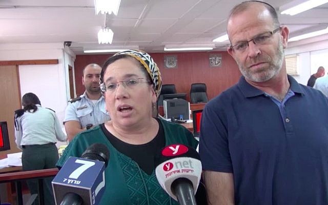 Nirit Zamoraà à gauche, parle aux journalistes dans la salle du tribunal militaire de Judée aux côtés de son mari avant la condamnation de son agresseur, le 16 juillet 2018 (Capture d'écran/Israel National News)