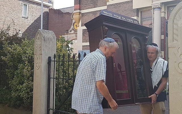 Tom Furstenberg, à droite, et membre de la communauté juive de Deventer transporte une arche à Torah hors de l'ancienne synagogue qu'il s'apprête à quitter, le 30 juillet 2018  Crédit : Cnaan Liphshiz/JTA)
