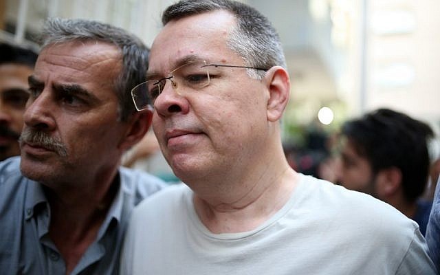 Le pasteur Brunson, à droite, escorté par la police turque lors de son arrivée à son domicile d'Izmir, le 25 juillet 2018 (Crédit : AFP PHOTO / STRINGER Le pasteur Brunson, à droite, escorté par la police turque lors de son arrivée à son domicile d'Izmir, le 25 juillet 2018 (Crédit : AFP PHOTO / STRINGER