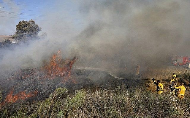 Les pompiers éteignent un incendie à proximité de Sdérot, dans le sud du pays, causé par un ballon incendiaire de la bande de Gaza, le 31 juillet 2018 (Crédit : AFP Photo/Menahem Kahana) Les pompiers éteignent un incendie à proximité de Sdérot, dans le sud du pays, causé par un ballon incendiaire de la bande de Gaza, le 31 juillet 2018 (Crédit : AFP Photo/Menahem Kahana)