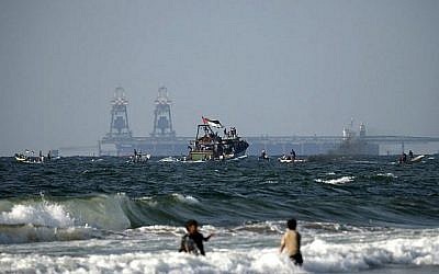 Des bateaux palestiniens participent à une manifestation contre le blocus de sécurité israélo-égyptien de Gaza, à Beit Lahya, à la frontière avec Israël dans le nord de la bande de Gaza, le 11 août 2018. La centrale électrique israélienne de Rutenberg est visible à l'arrière-plan. (AFP PHOTO / MAHMUD JAMBON) Des bateaux palestiniens participent à une manifestation contre le blocus de sécurité israélo-égyptien de Gaza, à Beit Lahya, à la frontière avec Israël dans le nord de la bande de Gaza, le 11 août 2018. La centrale électrique israélienne de Rutenberg est visible à l'arrière-plan. (AFP PHOTO / MAHMUD JAMBON)