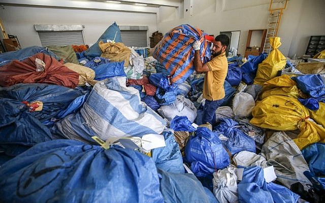 Un employé palestinien des services postaux trie les sacs de courrier qui n'a pas été livré depuis 2010, à Jéricho, en Cisjordanie, le 14 août 2018. (Crédit : AFP / ABBAS MOMANI)