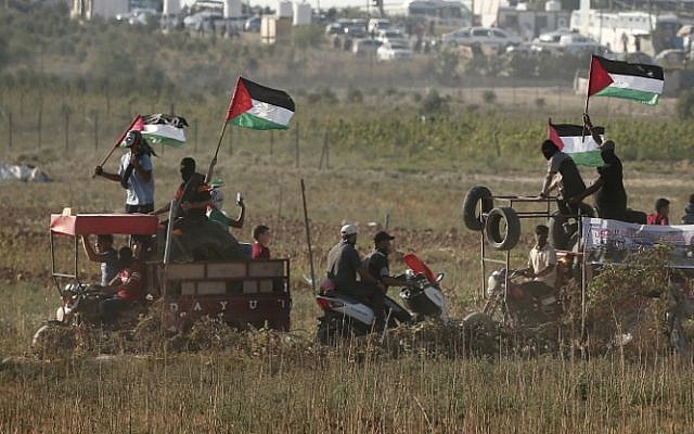Des manifestants palestiniens portent des pneus à brûler lors d'un rassemblement le long de la frontière entre Israël et la bande de Gaza, à l'est de la ville de Gaza, le 17 août 2018. (AFP PHOTO / MAHMUD HAMS) Des manifestants palestiniens portent des pneus à brûler lors d'un rassemblement le long de la frontière entre Israël et la bande de Gaza, à l'est de la ville de Gaza, le 17 août 2018. (AFP PHOTO / MAHMUD HAMS)