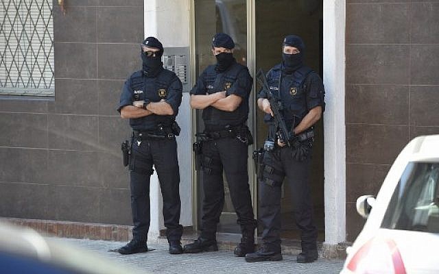 La police régionale de Catalogue monte la garde devant l'immeuble où vit un homme qui à tenté d'attaquer un poste de police, à Barcelone, le 20 août 2018. (Crédit : AFP/LLUIS GENE)