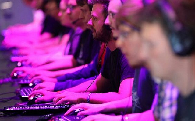 Des visiteurs testent jeux vidéos au Gamescom de Cologne, le 22 août 2018. (Crédit : AFP PHOTO / dpa / Oliver Berg / Germany OUT)