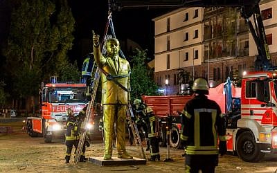 Des employés municipaux déboulonnent une statue de Recep Tayyip Erdogan, le 29 août à Wiesbaden, en Allemagne. (Crédit : AFP / dpa / Sebastian Stenzel / Germany OUT)