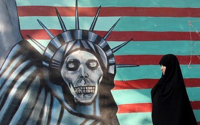 Une Iranienne promène son chien devant une fresque sur le mur de l'ancienne ambassade américaine à Téhéran, le 9 novembre 2016. (Crédit : AFP/Atta Kenare) Une Iranienne promène son chien devant une fresque sur le mur de l'ancienne ambassade américaine à Téhéran, le 9 novembre 2016. (Crédit : AFP/Atta Kenare)