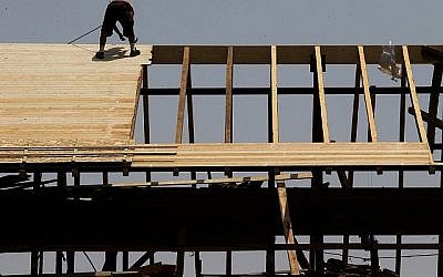 Un ouvrier travaille sur un toit d'un chantier de construction à Jérusalem, le 5 août 2015 (Nati Shohat/Flash90).