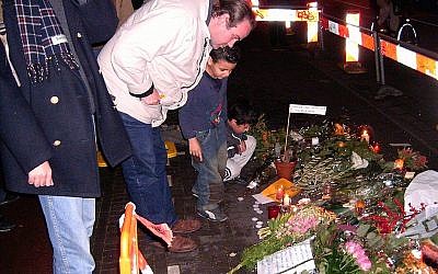 Les visiteurs d’un mémorial de fortune qui marque l'endroit où le cinéaste Theo van Gogh a été assassiné à Amsterdam, le 2 novembre 2004. (Crédit : Wikimedia Commons / via JTA)