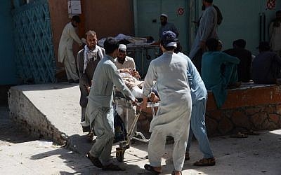 Des volontaires et des parents afghans transportent une victime blessée sur une civière pour qu'elle reçoive des soins médicaux au Pakistan le lendemain d'un attentat-suicide visant des manifestants dans le district de Mohmand Dara de la province de Nangarhar, à Jalalalabad, le 12 septembre 2018. (AFP PHOTO / NOORULLAH SHIRZADA)