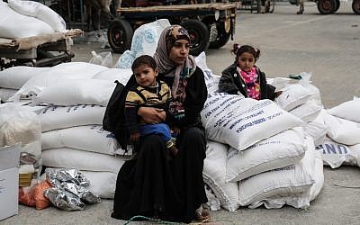 Une femme palestinienne avec ses enfants après avoir reçu des vivres au camp de réfugiés de Khan Younis, dans le sud de la bande de Gaza, le 11 février 2018. (AFP / Said Khatib)