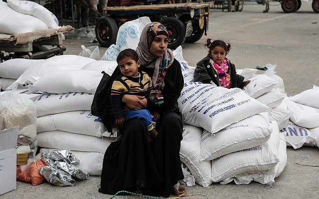 Une femme palestinienne avec ses enfants après avoir reçu des vivres au camp de réfugiés de Khan Younis, dans le sud de la bande de Gaza, le 11 février 2018. (AFP / Said Khatib)