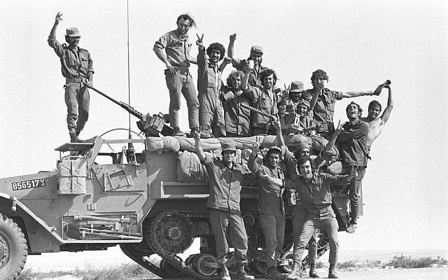 Des soldats  posent sur un tank au début de la guerre de Kippour  le 6 octobre 1973 (Crédit : Avi Simhoni/Bamahane/Archives du ministère de la Défense)