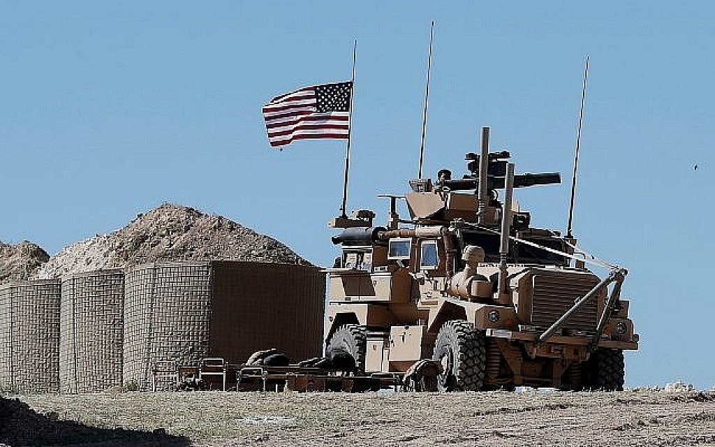 Un soldat américain assis sur un véhicule blindé à un nouveau poste de Manbij,  au nord de la Syrie, le 4 avril 2018 (Crédit : Hussein Malla/AP)