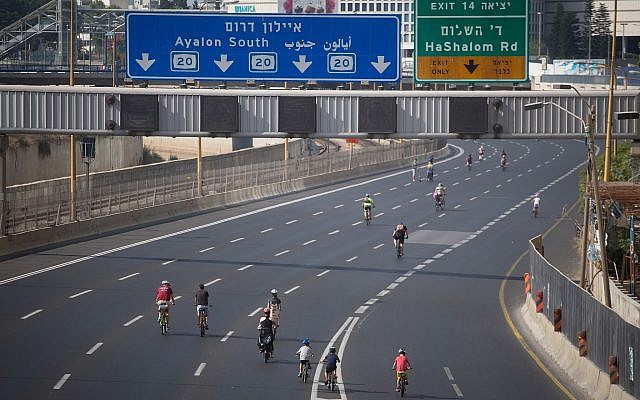Les Israéliens font du vélo le long de l'autoroute vide d'Ayalon à Tel Aviv, à Yom Kippour, le 19 septembre 2018 (Crédit : Miriam Alster/Flash 90) Les Israéliens font du vélo le long de l'autoroute vide d'Ayalon à Tel Aviv, à Yom Kippour, le 19 septembre 2018 (Crédit : Miriam Alster/Flash 90)