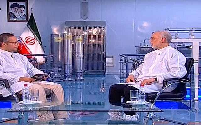 Capture d'écran d'une séquence vidéo d'Ali Akbar Salehi, chef de l'agence nucléaire iranienne, (à droite) et de trois centrifugeuses d'enrichissement en uranium en arrière plan. (Crédit : YouTube)