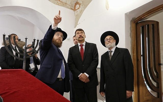 Le rabbin Slomo Koves, président de l'EMIH, à gauche, avec le président hongrois Janos Ader, au centre, et le grand rabbin de Hollande, Benjamin Jacobs, examinent les inscriptions au plafond de la synagogue médiévale à Budapest, le 6 septembre 2018 (Crédit : Márton Merész)