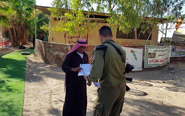 Le 23 septembre 2018, un fonctionnaire de l'administration civile remet à l'un de ses résidents un avis concernant la démolition imminente de Khan al-Ahmar (Crédit : Administration civile).