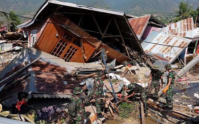 Des secouristes recherchent des survivants dans une maison effondrée à Balaroa, Palu occidental, dans le centre de Sulawesi, en Indonésie, le 3 octobre 2018, après qu'un tremblement de terre et un tsunami ont frappé la région le 28 septembre. (AFP/Yusuf Wahil) Des secouristes recherchent des survivants dans une maison effondrée à Balaroa, Palu occidental, dans le centre de Sulawesi, en Indonésie, le 3 octobre 2018, après qu'un tremblement de terre et un tsunami ont frappé la région le 28 septembre. (AFP/Yusuf Wahil)