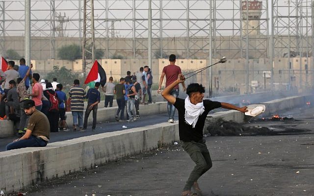 Un homme utilise un lance-pierre alors que des Palestiniens manifestent au poste frontière d'Erez avec Israël dans le nord de la bande de Gaza, le 3 octobre 2018. (AFP PHOTO / Said KHATIB)