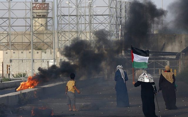 Une Palestinienne porte un drapeau lors d'une manifestation au poste frontière d'Erez avec Israël dans le nord de la bande de Gaza, le 3 octobre 2018. (AFP/ Said KHATIB)
