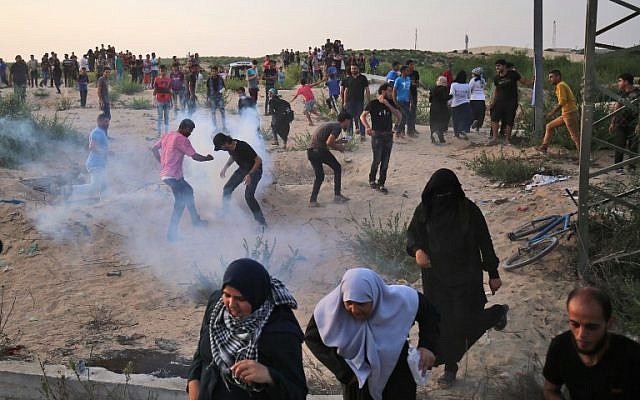 Des Palestiniens manifestent dans des fumées de gaz lacrymogène au poste frontière d'Erez avec Israël dans le nord de la bande de Gaza le 3 octobre 2018. (AFP PHOTO / DIT KHATIB)
