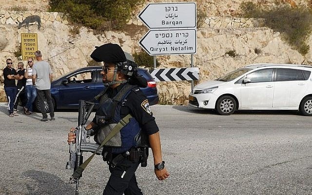 Les forces de sécurité israéliennes sur le site d'un attentat terroriste au parc industriel Barkan, à proximité de l'implantation d'Ariel, dans le nord de la Cisjordanie, le 7 octobre 2018 (Crédit : AFP Photo/Jack Guez)