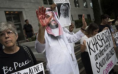 Un manifestant déguisé en prince saoudien Mohammed bin Salman (C), le visage ensanglanté, manifestait devant les locaux de l'ambassade saoudienne à Washington, le 8 octobre 2018, pour demander que justice soit rendue pour le journaliste égaré Jamal Khashoggi. (Crédit : Jim Watson / AFP)