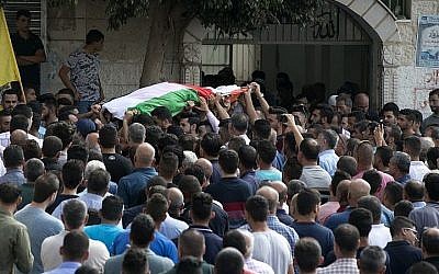 Des Palestiniens transportent le corps d'Aisha Rabi, mère de huit enfants, 48 ans, morte de ses blessures après que sa voiture a fait l'objet d'un caillassage, pendant ses funérailles à Biddya, en Cisjordanie, le 13 octobre 2018 (Crédit : JAAFAR ASHTIYEH / AFP)