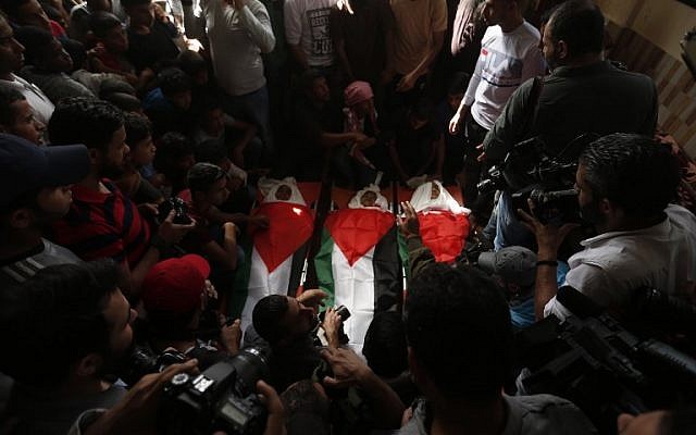 Funérailles de trois adolescents, qui ont été tués dans une attaque aérienne israélienne, enveloppés de drapeaux palestiniens, dans la ville de Deir el-Balah, au centre de la bande de Gaza, le 29 octobre 2018. (Crédit : MAHMUD HAMS / AFP) Funérailles de trois adolescents, qui ont été tués dans une attaque aérienne israélienne, enveloppés de drapeaux palestiniens, dans la ville de Deir el-Balah, au centre de la bande de Gaza, le 29 octobre 2018. (Crédit : MAHMUD HAMS / AFP)