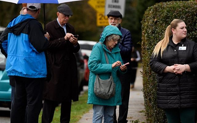 Les résidents vérifient leurs téléphones près du site d'une fusillade à la Synagogue Tree of Life dans le quartier de Squirrel Hill le 27 octobre 2018 à Pittsburgh, en Pennsylvanie. (Crédit : Jeff Swensen / Getty Images / AFP) Les résidents vérifient leurs téléphones près du site d'une fusillade à la Synagogue Tree of Life dans le quartier de Squirrel Hill le 27 octobre 2018 à Pittsburgh, en Pennsylvanie. (Crédit : Jeff Swensen / Getty Images / AFP)