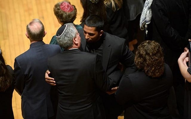 Wasi Mohamed, directeur exécutif du Centre islamique de Pittsburgh, est pris dans les bras par un rabbin après s'être adressé à l'auditoire au cours d'une cérémonie en l'honneur des victimes de la fusillade de samedi à la synagogue Tree Of Life. (Crédit : Jeff Swensen / Getty Images / AFP)