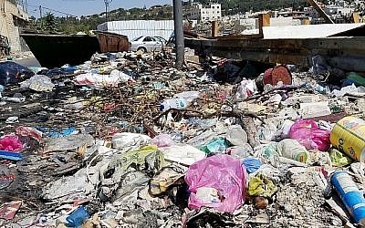 Les ordures empilées dans le quartier de Wadi Joz, à Jérusalem, sur un côté de la rue, le 23 septembre 2018 (Crédit : Adam Rasgon/Times of Israel)