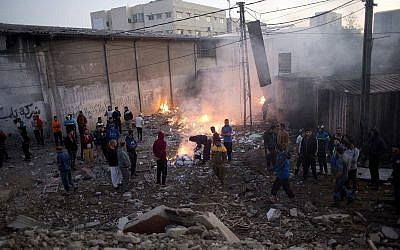 Les Palestiniens vérifient les dégâts causés aux bâtiments détruits par les frappes aériennes israéliennes à Gaza le 27 octobre 2018 après des tirs de roquettes depuis Gaza. (Crédit : AP / Khalil Hamra)