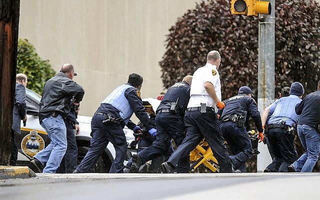 Les forces de l'ordre ont conduit une personne sur une civière sur le lieu de la fusillade où plusieurs personnes ont été tuées par balle, le samedi 27 octobre 2018, dans la synagogue Tree of Life dans le quartier de Squirrel Hill à Pittsburgh. (Crédit : Alexandra Wimley / Pittsburgh Post-Gazette via AP) Les forces de l'ordre ont conduit une personne sur une civière sur le lieu de la fusillade où plusieurs personnes ont été tuées par balle, le samedi 27 octobre 2018, dans la synagogue Tree of Life dans le quartier de Squirrel Hill à Pittsburgh. (Crédit : Alexandra Wimley / Pittsburgh Post-Gazette via AP)