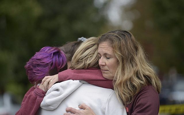 De gauche à droite, Cody Murphy, 17 ans, Sabrina Weihrauch, et Amanda Godley, toutes à Pittsburgh, étreintes après une fusillade à la synagogue Tree of Life, le samedi 27 octobre 2018. (Crédit : Andrew Stein / Pittsburgh Post-Gazette via AP) De gauche à droite, Cody Murphy, 17 ans, Sabrina Weihrauch, et Amanda Godley, toutes à Pittsburgh, étreintes après une fusillade à la synagogue Tree of Life, le samedi 27 octobre 2018. (Crédit : Andrew Stein / Pittsburgh Post-Gazette via AP)