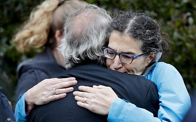 Des gens se réconfortent dans le quartier Squirrel Hill de Pittsburgh après une fusillade survenue à la synagogue Tree of Life le 27 octobre 2018 (Crédit : AP/Keith Srakocic)