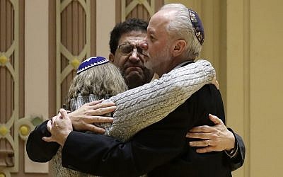 Le rabbin Jeffrey Myers, à droite, de la congrégation Tree of Life/Or L'Simcha étreint le rabbin Cheryl Klein, à gauche, de la congrégation Dor Hadashet le rabbin  Jonathan Perlman pendant un rassemblement organisé suite à la fusillade meurtrière de la synagogue Tree of Life à  Pittsburgh, le 28 octobre 2018 (Crédit :  AP Photo/Matt Rourke)