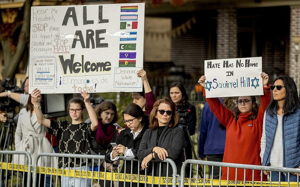 Des manifestants brandissent des pancartes alors que le président Donald Trump et la first lady Melania Trump visitent la synagogue Tree of Life de  Pittsburgh, le mardi 30 octobre 2018 (Crédit : AP Photo/Andrew Harnik)