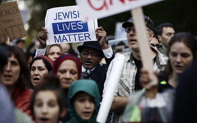 Des manifestants manifestent près de la synagogue Tree of Life à Pittsburgh où le président Donald Trump et la première dame Melania Trump rendaient hommage aux victimes la tuerie, le 30 octobre 2018. (Crédit : AP / Matt Rourke)