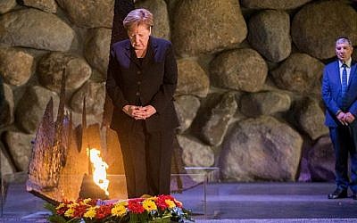 La chancelière allemande Angela Merkel dépose une couronne au cours d'une cérémonie dans la salle du souvenir du mémorial de la Shoah Yad Vashem à Jérusalem, le 4 octobre 2018 (Oren Ben Hakoon/POOL)