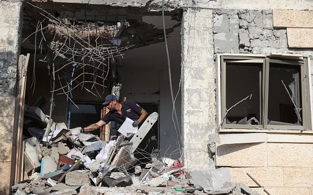 Les forces de sécurité israéliennes inspectent un bâtiment qui a été touché par une roquette tirée depuis la bande de Gaza dans la ville de Beer Sheva dans le sud d'Israël, le 17 octobre 2018. (Yonatan Sindel/Flash90) Les forces de sécurité israéliennes inspectent un bâtiment qui a été touché par une roquette tirée depuis la bande de Gaza dans la ville de Beer Sheva dans le sud d'Israël, le 17 octobre 2018. (Yonatan Sindel/Flash90)