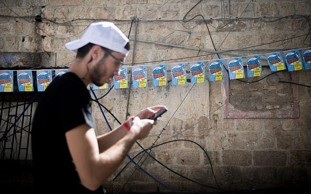 Un homme devant les affiches du candidat à la mairie de Jérusalem Yossi Deitch au marché Mahane Yehuda de Jérusalem, le 29 octobre 2018 (Crédit : Yonatan Sindel/Flash90) Un homme devant les affiches du candidat à la mairie de Jérusalem Yossi Deitch au marché Mahane Yehuda de Jérusalem, le 29 octobre 2018 (Crédit : Yonatan Sindel/Flash90)