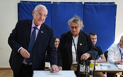 Le président Reuven Rivlin et son épouse Nechama déposent leur bulletin dans l'urne dans un bureau de vote le matin des élections municipales du 30 octobre 2018 à Jérusalem. (Crédit : Mark Neyman/GPO)