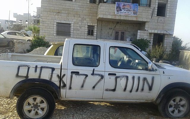 Une voiture taguée "mort aux meurtriers" , dont les pneus ont été lacérés, dans le village palestinien de Asira al-Qabaliya le 15 octobre 2018. (Crédit : Said Shartah)
