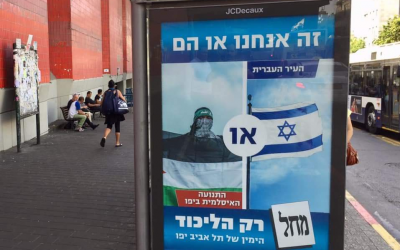 'une des affiches de campagne du Likud de Tel Aviv "C'est nous ou eux", à un arrêt de bus de Tel Aviv, en octobre 2018. (Crédit : Times of Israel Staff) 'une des affiches de campagne du Likud de Tel Aviv "C'est nous ou eux", à un arrêt de bus de Tel Aviv, en octobre 2018. (Crédit : Times of Israel Staff)